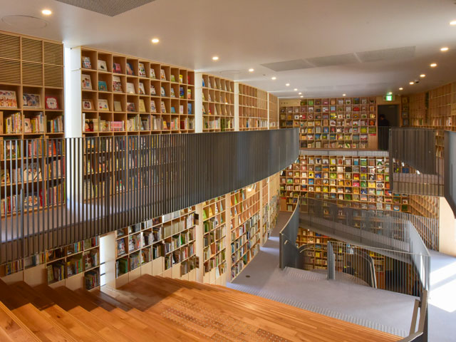 The entire wall is covered with books of every genre. Kids enjoy sitting on the stairs to read.